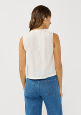 [Color: White] A back facing image of a brunette model wearing a white tank top with lace and eyelet detailing. 