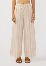 [Color: Sand/White] A front facing image of a brunette model wearing a beige striped bottom with wide legs and a an elastic drawstring waist.