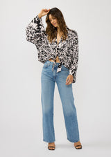 [Color: Vanilla/Black] A front facing image of a brunette model wearing a abstract floral kimono top with  an adjustable tie front and long billowy sleeves. 