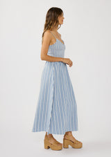 [Color: Blue/White] A side facing image of a brunette model wearing blue striped midi dress with a smocked bodice, v-neckline, and adjustable straps. A breezy cotton blend dress for vacation. 
