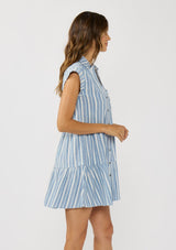 [Color: Blue/White] A side facing image of a brunette model wearing a blue striped mini dress with tiered skirt, short dolman sleeves, collared neckline, button front, and a single patch pocket. 