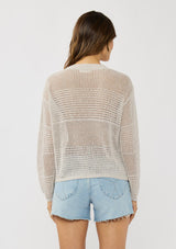 [Color: Stone] A back facing image of a brunette model wearing a grey knit top with silver metallic thread, a round neck, long sleeves, and open knit details. 