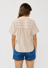 [Color: Sand/White] A back facing image of a brunette model wearing a cotton striped top with a surplice front, short dolman sleeves, and patch pockets.  