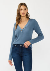 [Color: Heather Ocean] A front facing image of a brunette model wearing a blue waffle knit sweater top with a v neckline and a button front detail. 