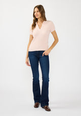[Color: Light Pink] A front facing image of a brunette model wearing a light pink waffle knit polo top with a collared neck and button front. 