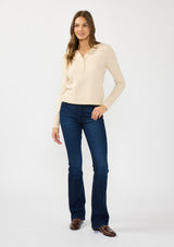 [Color: Stone] A front facing image of a brunette model wearing a beige sweater  polo with a button front, collared neck, and a cable knit detail on the sleeves. 