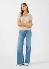 [Color: Heather Pearl] A front facing image of a brunette model wearing a light taupe waffle knit polo top with a collared neck and button front. 