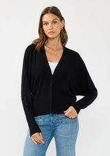 [Color: Black] A front facing image of a brunette model wearing a black button front cardigan with long dolman sleeves, a v neckline, and rib trims. 