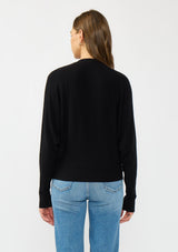 [Color: Black] A back facing image of a brunette model wearing a black button front cardigan with long dolman sleeves, a v neckline, and rib trims. 