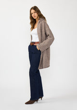 [Color: Heather Woodrose] A side facing image of a brunette model wearing a cozy wool blend coatigan with an oversized fit, hoodie, and side pockets. 