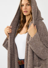 [Color: Heather Woodrose] A detail image of a brunette model wearing a cozy wool blend coatigan with an oversized fit, hoodie, and side pockets. 