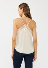 [Color: Vanilla] A back facing image of a brunette model wearing a lace trimmed camisole with a v neckline and adjustable spaghetti straps. 