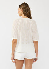 [Color: Natural/Cream] A back facing image of a brunette model wearing a white embroidered puff sleeve top with a button front. 