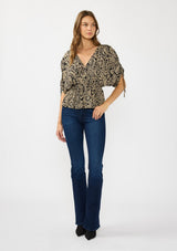 [Color: Black/Natural] A front facing image of a brunette model wearing a black and beige paisley print top with ruched sleeves, a v neckline, and an elastic peplum waist. 