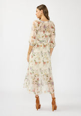 [Color: Ivory/Rosewood] A back facing image of a brunette model wearing an ivory floral midi dress with a waist belt, three quarter sleeves, and a v neckline. 
