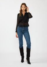 [Color: Black] A front facing image of a brunette model wearing a sheer black top with a front lace accent, button front, long sleeves, and a tie front waist detail. 