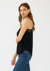 [Color: Black] A side facing image of a brunette model wearing a black lace trimmed camisole with a v neckline and adjustable spaghetti straps. 