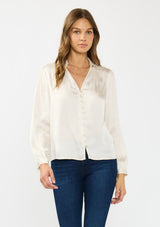 [Color: Eggshell] A front facing image of a brunette model wearing a white satin blouse with a collar, v-neckline, button front, and long sleeves. 