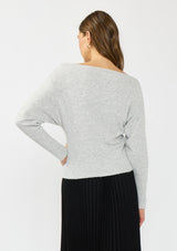 [Color: Heather Lunar] A back facing image of a brunette model wearing a light grey pullover sweater with an off shoulder design, boat neckline, and ribbed cuffs. 