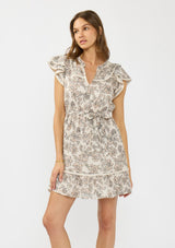 [Color: Cream/Black] A front facing image of a brunette model wearing a cream and black floral mini dress with flutter sleeves, a split v neckline, lace trims, and a self tie waist belt. 