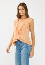 [Color: Sorbet] A side facing image of a brunette model wearing an orange flutter sleeve top with lace trims, a button front, and a ruffle trimmed hem. Styled with a blue patch pocket denim. 