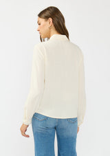 [Color: Natural] A back facing image of a brunette model wearing an off white lace shirt with a collared neck and button front. 