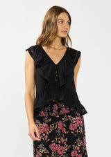 [Color: Black] A front facing image of a brunette model wearing a black flutter sleeve top with lace trims, a button front, and a ruffle trimmed hem. 