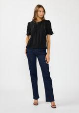 [Color: Black] A front facing image of a brunette model wearing a black puff sleeve top with a round neck, lace trims, and pintucks.
