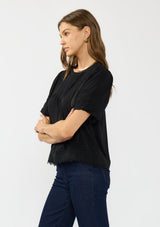 [Color: Black] A side facing image of a brunette model wearing a black puff sleeve top with a round neck, lace trims, and pintucks.