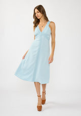 [Color: Blue] A front facing image of a brunette model wearing a light blue sleeveless midi dress with lace trim accents, a v neckline, and an empire waist. 