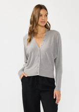 [Color: Heather Grey] A front facing image of a brunette model wearing a grey button front cardigan with long dolman sleeves, a v neckline, and rib trims. 