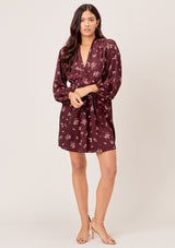 [Color: Merlot Rose] A romantic, vintage inspired floral mini dress. Featuring a v neckline, a waist defining tie back detail, and voluminous long sleeves.