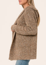 [Color: Mocha] A close up side facing image of a blonde model wearing a fuzzy brown boucle hooded cardigan. With long sleeves and an open front. 