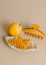 [Color: Citrus]  Yellow hair clips with an orange.