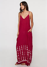 [Color: Wine] Woman wearing a burgundy bohemian maxi dress with a border print. Featuring a relaxed silhouette, a v neckline, adjustable spaghetti straps, and side pockets. 