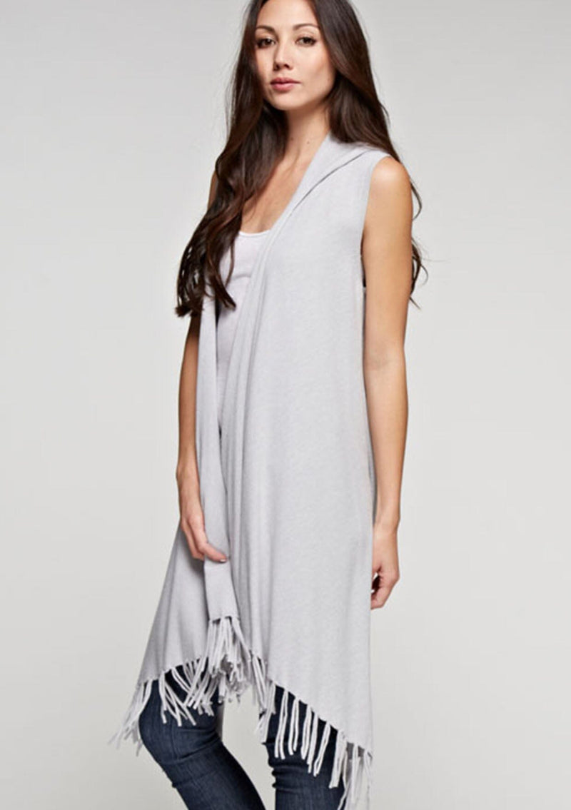 [Color: Heather Silver] A woman wearing a hooded knit fringe vest. Featuring a trending fringed hemline and an easy open front.