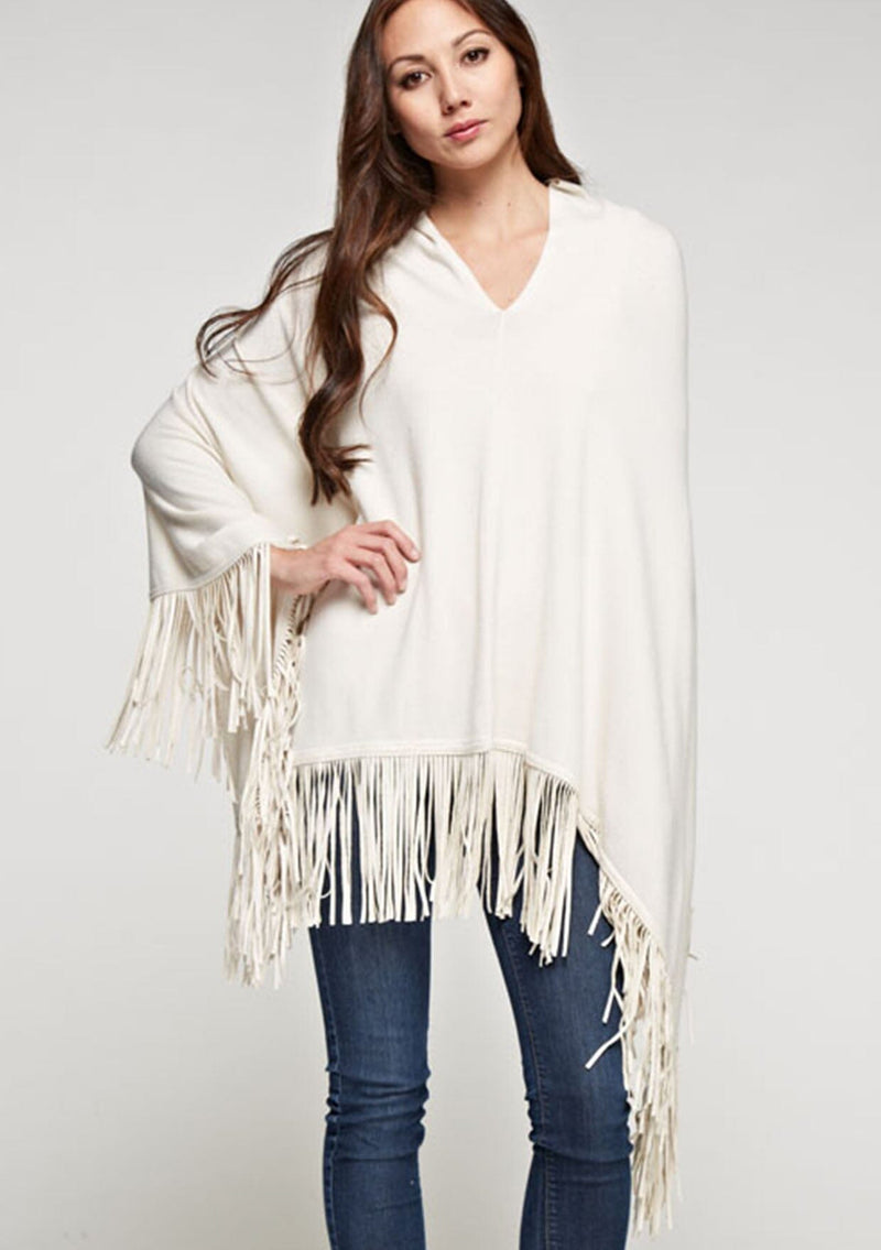 [Color: Vanilla] A front facing image of a blonde model wearing an ivory suede fringed poncho. 