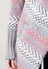 [Color: Ivory/Ocean/Rose] A blonde model wearing a boho striped cardigan with a cozy shawl collar and side pockets. A statement boho cardigan for the fall season. 