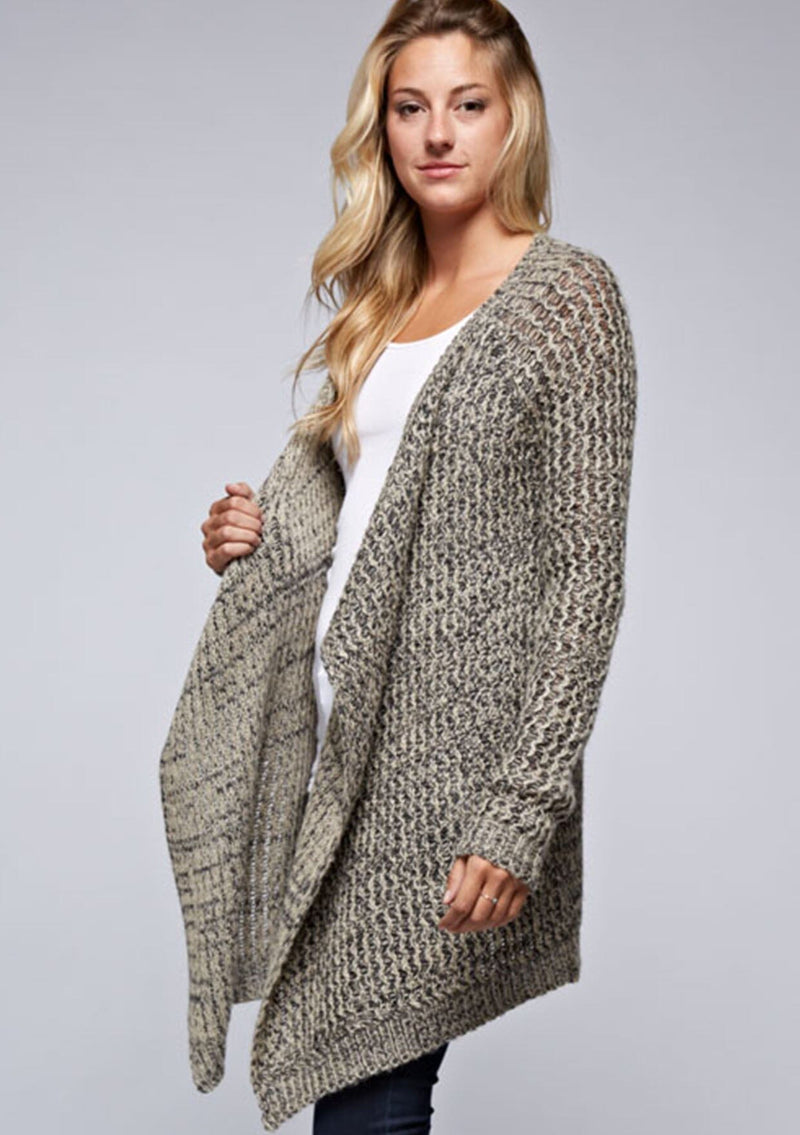 [Color: Black/Natural] A side facing image of a blonde model wearing a marled knit black and beige cardigan with a shawl collar and cozy long sleeves. A casual fall cardigan. 