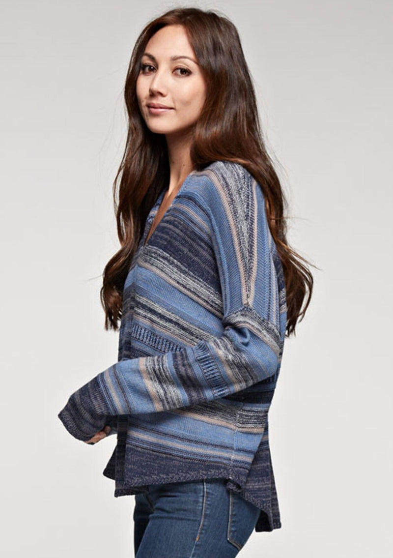 [Color: Blue Combo] A brunette model wearing a boho striped knit hoodie with a v-neckline and long sleeves. 
