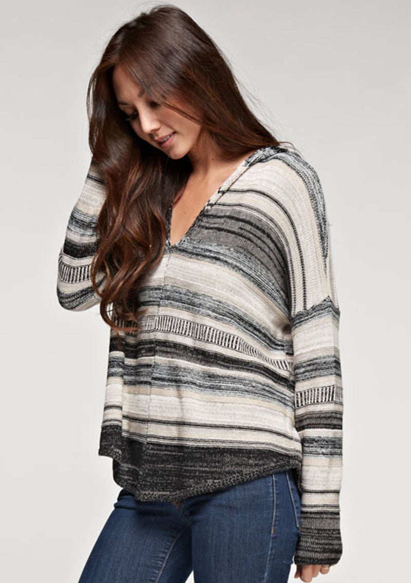 [Color: Taupe Combo] A brunette model wearing a boho striped knit hoodie with a v-neckline and long sleeves. 