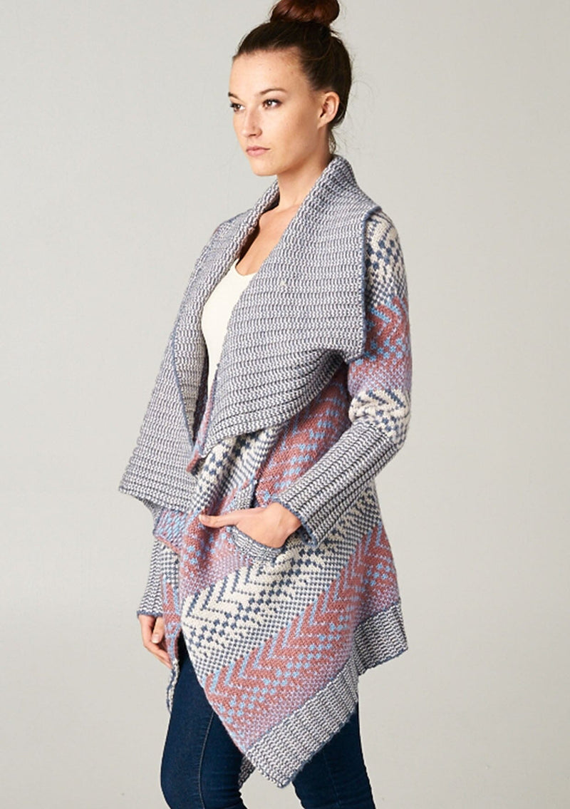 [Color: Ivory/Ocean/Rose] A blonde model wearing a boho striped cardigan with a cozy shawl collar and side pockets. A statement boho cardigan for the fall season. 