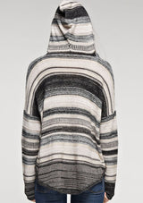 [Color: Taupe Combo] A brunette model wearing a boho striped knit hoodie with a v-neckline and long sleeves. 