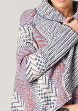 [Color: Ivory/Ocean/Rose] A blonde model wearing a boho striped cardigan with a cozy shawl collar and side pockets. A statement boho cardigan for the fall season. 