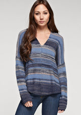 [Color: Blue Combo] A brunette model wearing a boho striped knit hoodie with a v-neckline and long sleeves. 