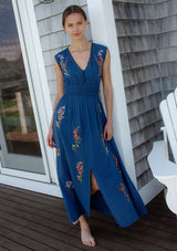 [Color: Navy] A front facing image of a blonde model wearing a blue embroidered maxi dress with w scalloped v-neckline, a smocked waist, and slits. A flowy summer dress for garden parties and soirees. 