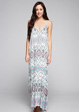 [Color: Black/Aqua/Multi] A front facing image of a brunette model wearing bohemian maxi dress with a blue geometric print, spaghetti straps, and a  racerback with tassel ties. 