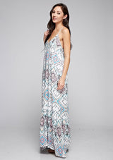[Color: Black/Aqua/Multi] A side facing image of a brunette model wearing bohemian maxi dress with a blue geometric print, spaghetti straps, and a  racerback with tassel ties. 
