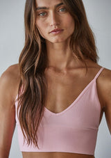 [Color: Pink] A front facing image of a brunette model wearing a basic light pink bralette cami with a slim stretchy fit and a v neckline.