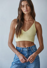 [Color: Sunshine] A front facing image of a brunette model wearing a basic yellow bralette cami with a slim stretchy fit and a v neckline.